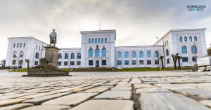 The stately exterior of the University of Bergen building with a statue in front, representing the academic institution where the Spillforsk study on youth gambling problems and loot boxes was conducted in Norway.