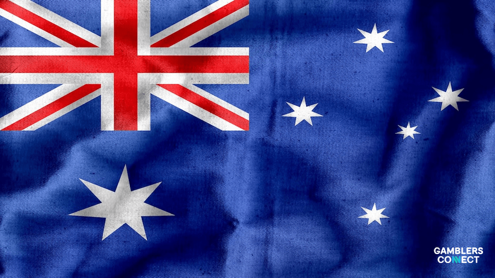 The Australian flag waving in the wind, symbolizing the federal and territory-level regulations governing the country's gambling industry.