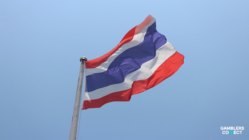 A view of the Thai flag on a flagpole, symbolizing the state's industrial-scale enforcement against digital crime syndicates and illegal betting networks.