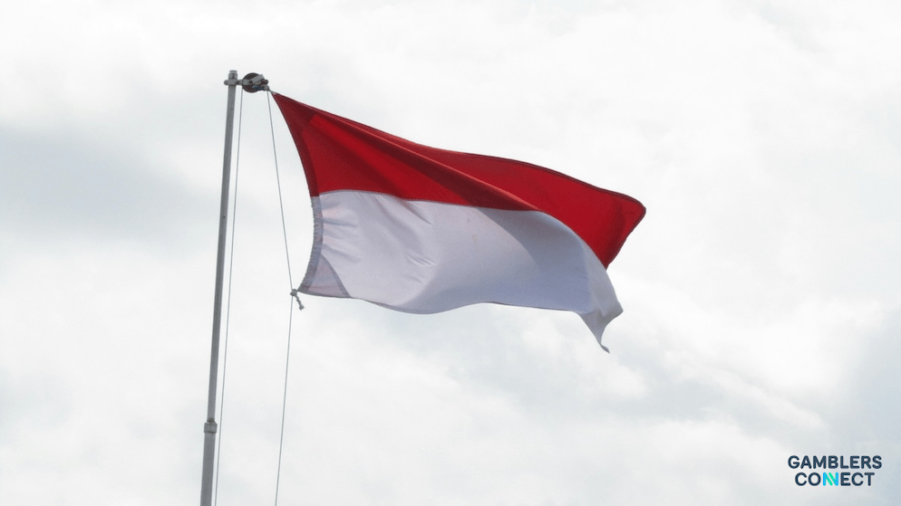 A low-angle shot of the Indonesian flag, symbolizing the strict enforcement of Article 303 of the Penal Code against both physical and online betting. by the Riau Islands police.