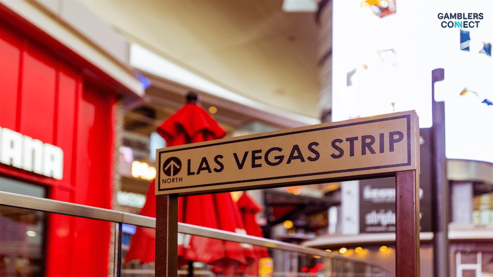 Formula One race cars speeding down the Las Vegas Strip at night, illuminated by casino lights.