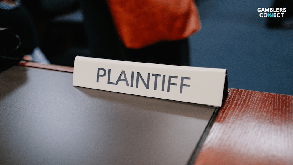 A legal placard on a wooden table, representing the federal charges and subsequent settlements agreed to by former executives Matthew Clemenson and Ryan Dickinson.