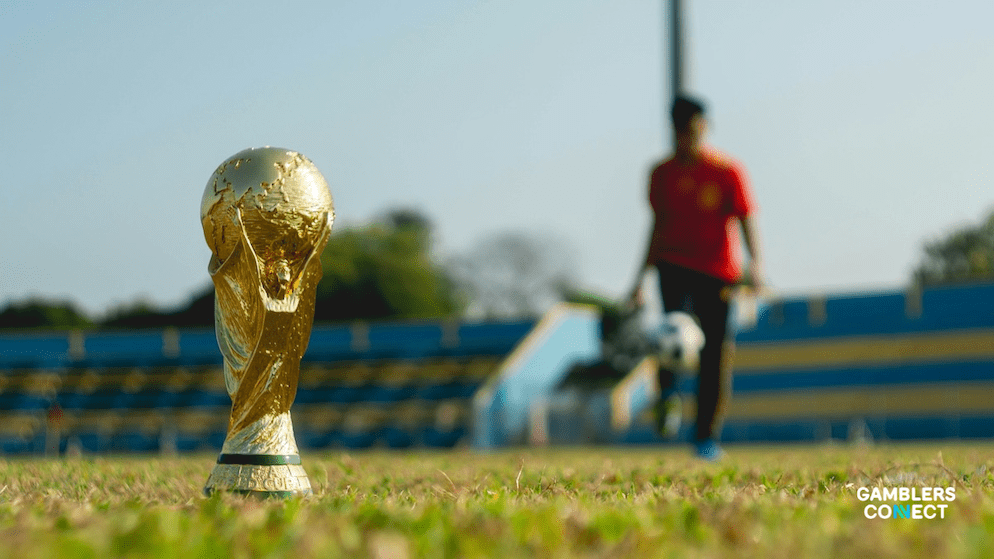 A golden football trophy on a green field, symbolizing the prize sought by 48 nations in the expanded 2026 World Cup hosted by the USA, Mexico, and Canada.