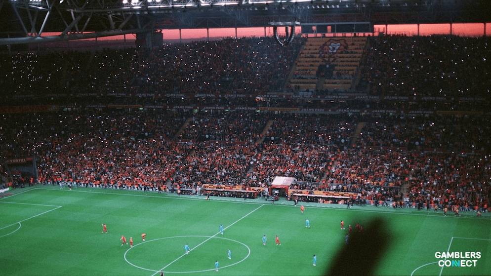 A wide shot of a Turkish football match in progress, symbolizing the broader investigation that has implicated referees, players, and the Galatasaray General Secretary,  club officials across the league.