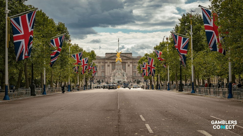 British flags waving in London, symbolizing the regulatory changes and potential budget deficits facing the UK's gambling oversight body.