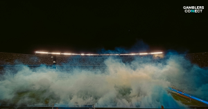 A wide shot of a crowded football stadium filled with atmospheric smoke, representing the intense scale of the upcoming 2026 FIFA World Cup.