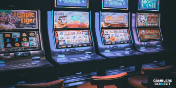 A row of glowing slot machines in a dimly lit casino, representing the 43.7% revenue dominance of slots in North American gambling for 2025.
