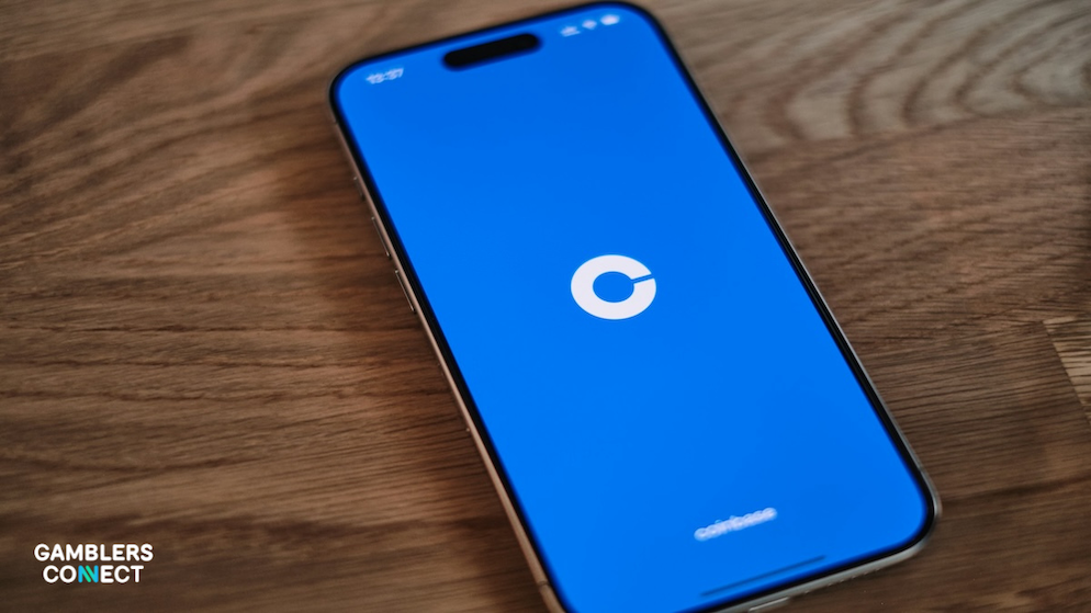 A blue smartphone screen representing Coinbase's 'Everything Exchange' strategy and its mass-market Super Bowl commercial.