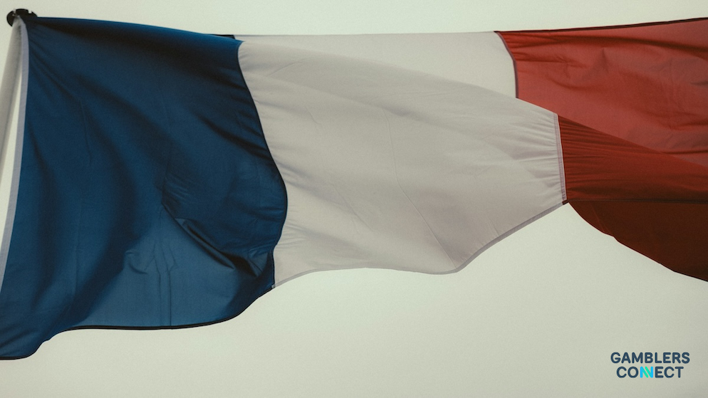 A close-up shot of a modern glass office building in Paris, representing the headquarters of French gaming regulators.